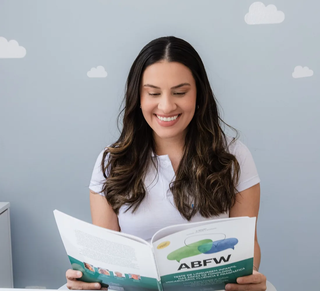 Dani lendo o livro de avaliação ABFW