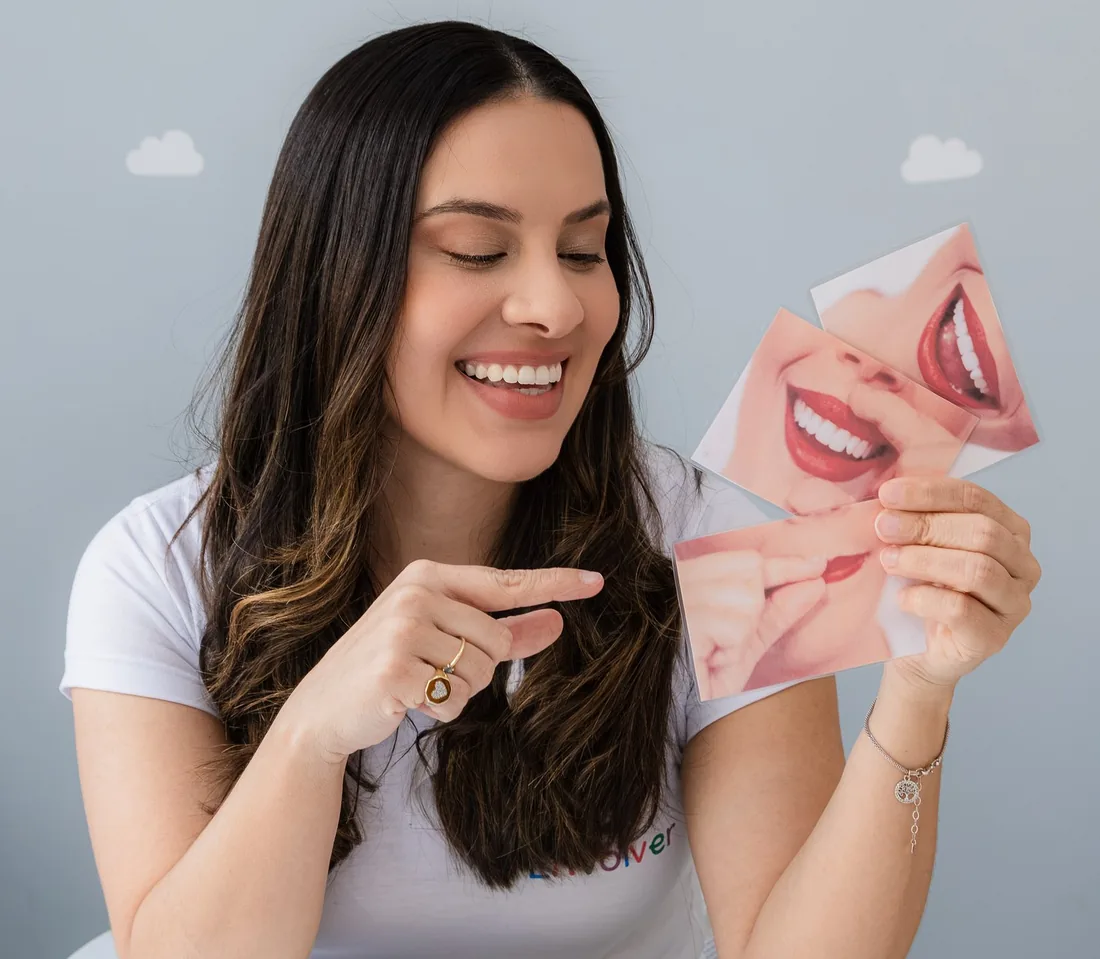 Dani mostrando cartões com fotos de bocas